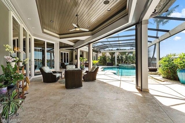 view of patio / terrace featuring a lanai, ceiling fan, a swimming pool with hot tub, and french doors