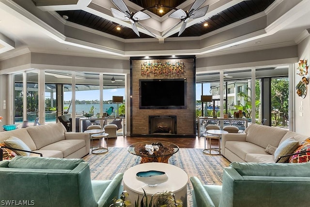 living room featuring a fireplace, ceiling fan, and ornamental molding