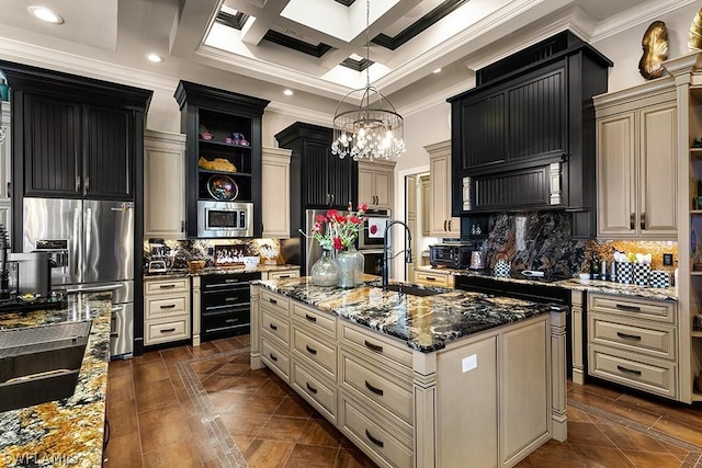 kitchen with backsplash, dark stone countertops, a kitchen island with sink, and appliances with stainless steel finishes