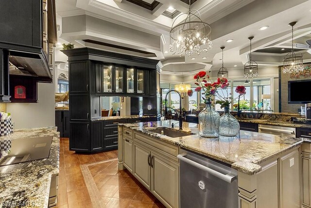 kitchen with dishwasher, a center island with sink, sink, light stone countertops, and decorative light fixtures