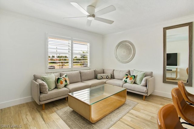 living room with ornamental molding, ceiling fan, and light wood-type flooring