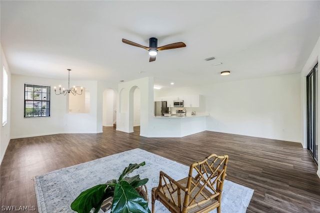 living room featuring ceiling fan with notable chandelier and dark hardwood / wood-style floors