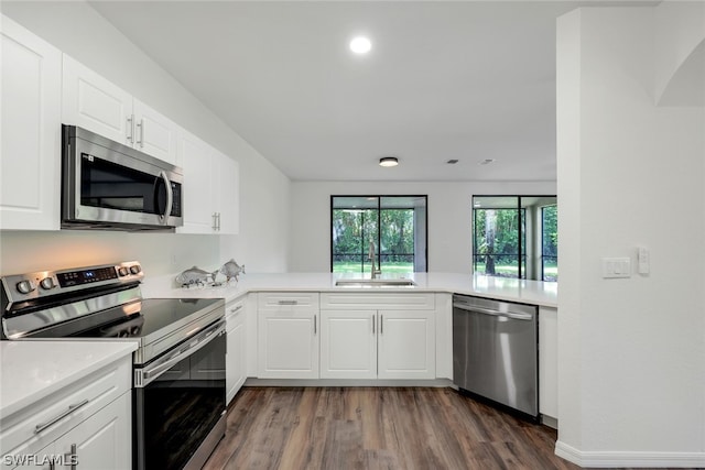 kitchen with white cabinets, stainless steel appliances, kitchen peninsula, and sink