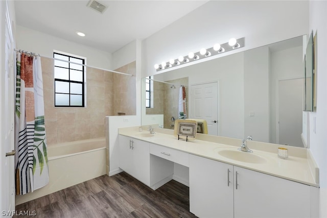 bathroom with hardwood / wood-style floors, vanity, and shower / bath combo with shower curtain