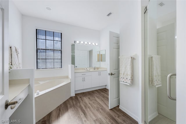 bathroom with shower with separate bathtub, vanity, and wood-type flooring