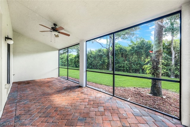 unfurnished sunroom featuring ceiling fan