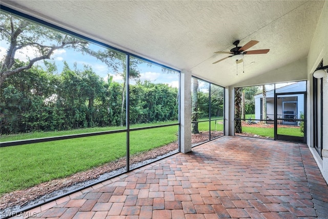 unfurnished sunroom with ceiling fan and vaulted ceiling