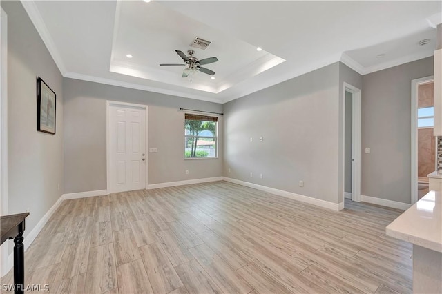 spare room featuring ceiling fan, a raised ceiling, and light hardwood / wood-style floors