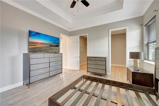 bedroom featuring a raised ceiling, crown molding, ceiling fan, and light hardwood / wood-style floors