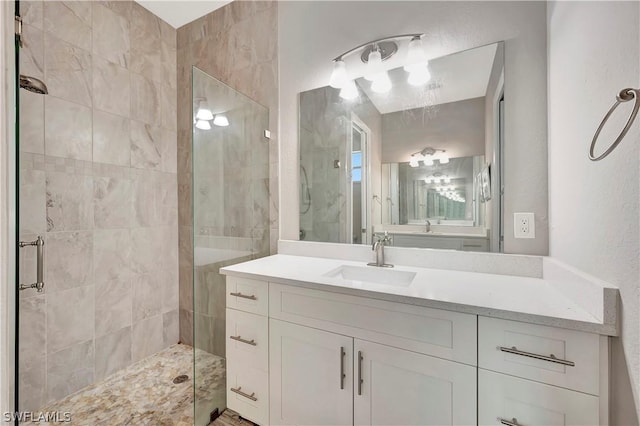 bathroom with a shower with door and vanity