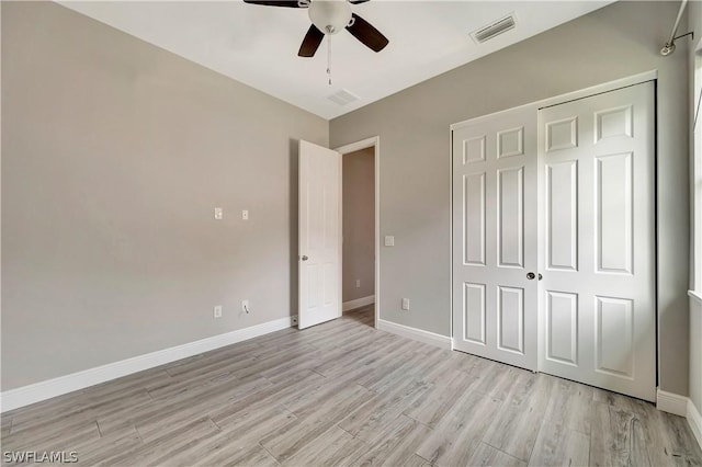 unfurnished bedroom featuring ceiling fan, a closet, and light wood-type flooring