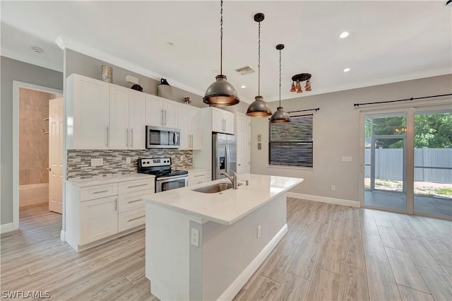 kitchen featuring a kitchen island with sink, sink, white cabinets, and appliances with stainless steel finishes