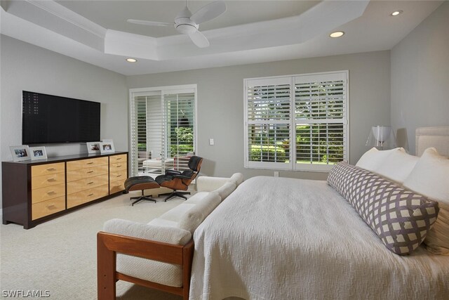 bedroom with carpet flooring, ceiling fan, and a tray ceiling