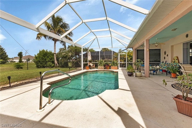 view of pool featuring a lawn, a patio, a lanai, and ceiling fan