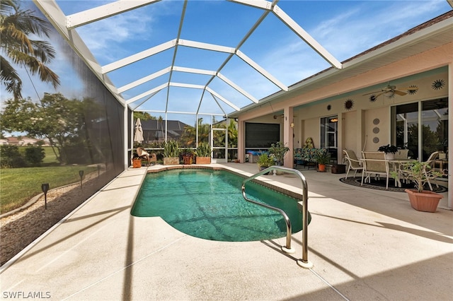 view of swimming pool featuring a patio, ceiling fan, and glass enclosure