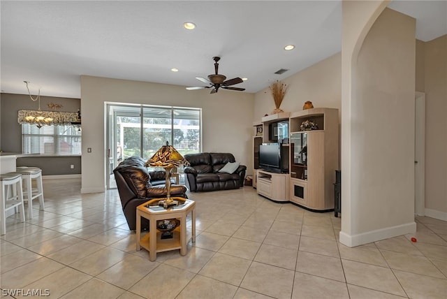 tiled living room featuring ceiling fan with notable chandelier