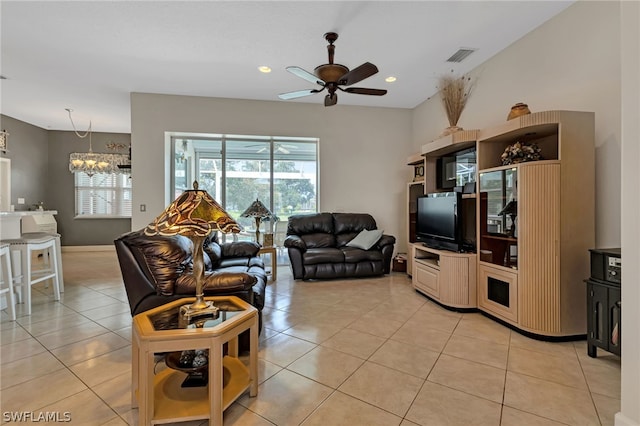 living room with ceiling fan with notable chandelier and light tile patterned floors