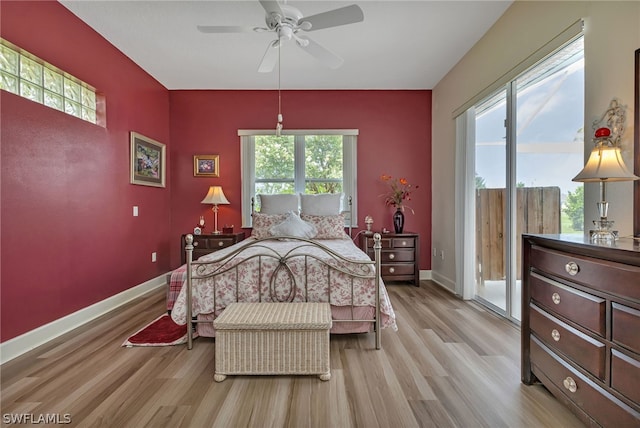 bedroom with light hardwood / wood-style floors, multiple windows, and access to exterior