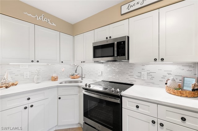 kitchen featuring white cabinetry, tasteful backsplash, appliances with stainless steel finishes, and sink