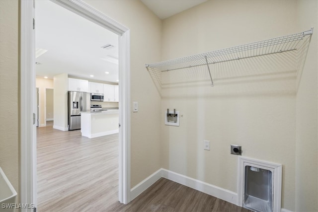 clothes washing area with light hardwood / wood-style flooring, washer hookup, and hookup for an electric dryer