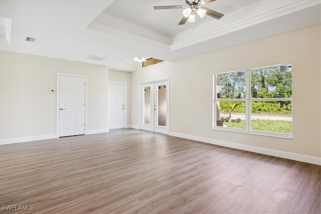 unfurnished room with a raised ceiling, ceiling fan, hardwood / wood-style floors, and french doors