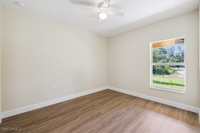 empty room featuring hardwood / wood-style flooring, ceiling fan, and a healthy amount of sunlight