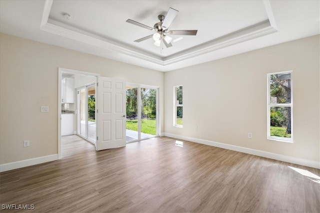 spare room featuring a tray ceiling, ceiling fan, and wood-type flooring