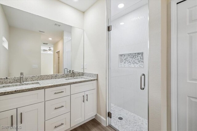 bathroom with ceiling fan, a shower with door, vanity, and hardwood / wood-style flooring