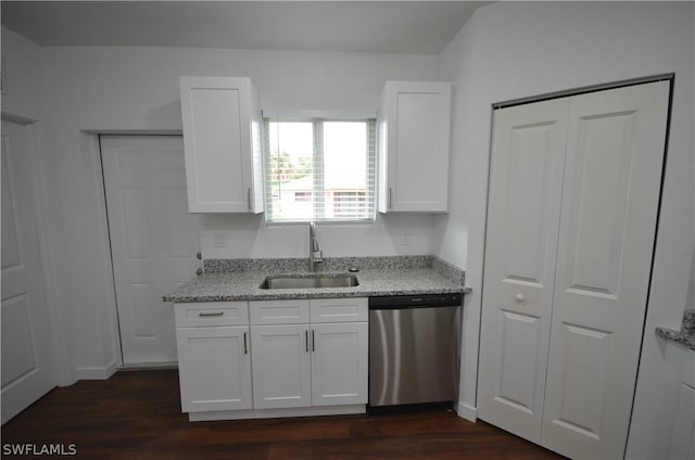 kitchen featuring stainless steel dishwasher, light stone countertops, sink, and white cabinets