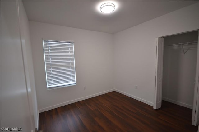 unfurnished bedroom with dark hardwood / wood-style floors and a closet