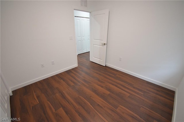 spare room with dark hardwood / wood-style flooring