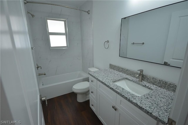 full bathroom with vanity, tiled shower / bath, hardwood / wood-style flooring, and toilet