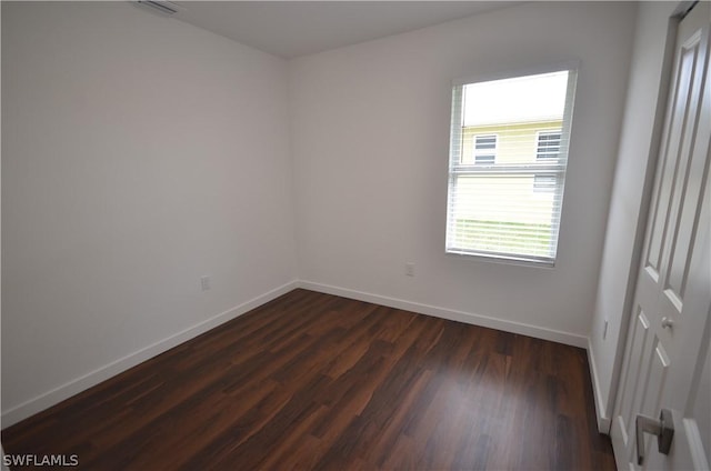 spare room with dark wood-type flooring