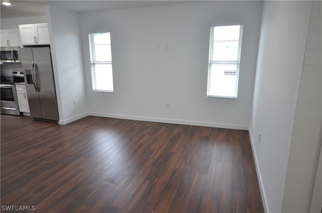 interior space featuring white cabinetry, dark wood-type flooring, and stainless steel appliances