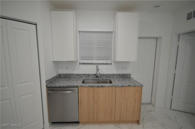 kitchen with white cabinetry, stainless steel dishwasher, stone countertops, and sink