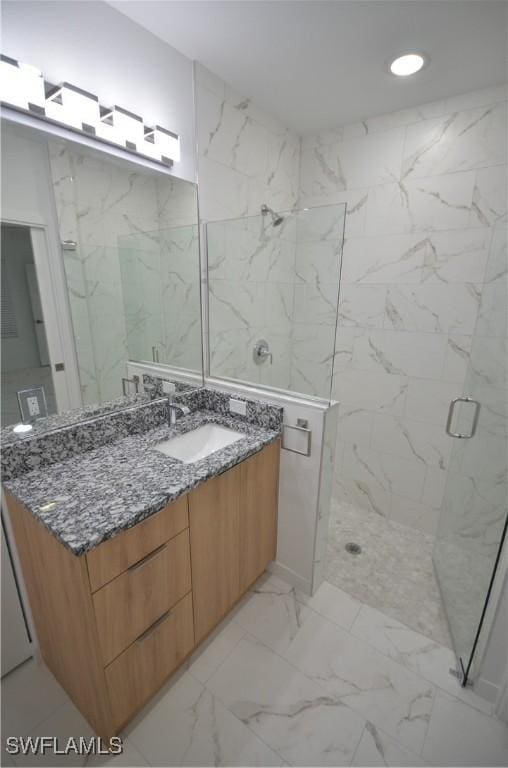 bathroom featuring vanity and a shower with door