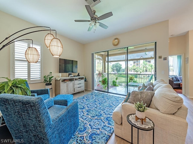 living room featuring ceiling fan and a wealth of natural light