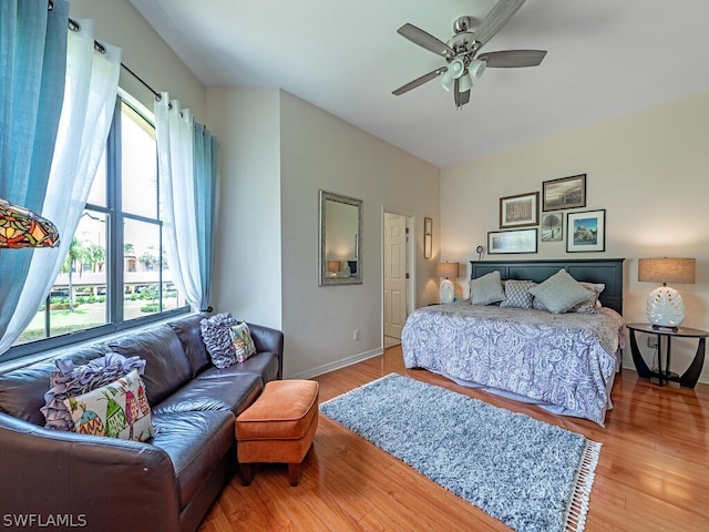 bedroom featuring multiple windows, hardwood / wood-style flooring, and ceiling fan