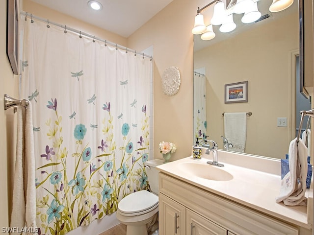 bathroom featuring walk in shower, vanity, and toilet