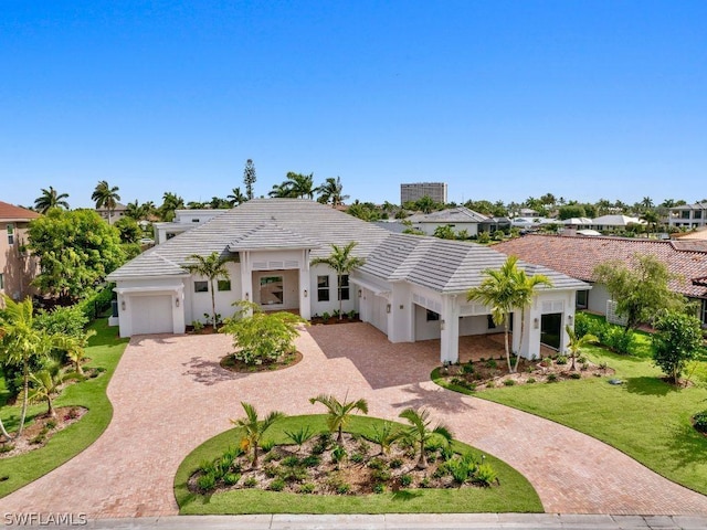 view of front of home featuring a front lawn, decorative driveway, and a tiled roof