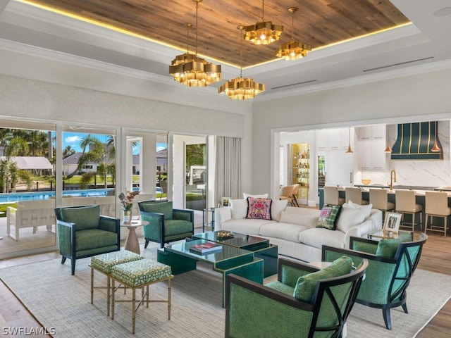 living room featuring a raised ceiling, wood-type flooring, a chandelier, and wooden ceiling