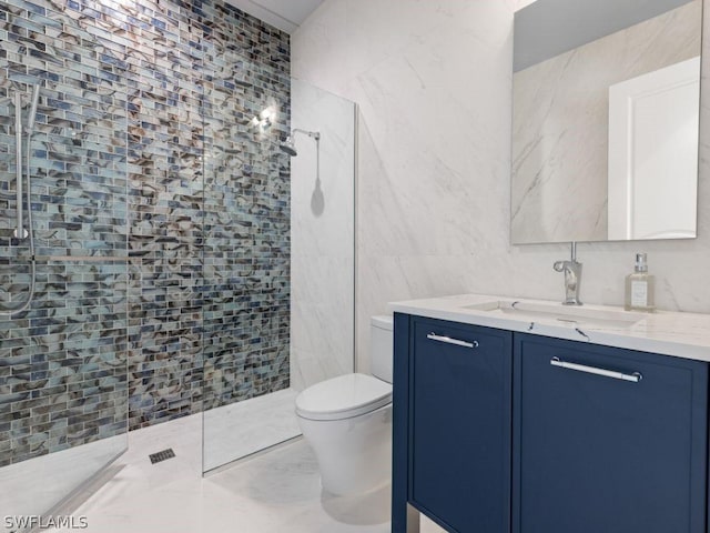 bathroom featuring tile walls, toilet, vanity, and a tile shower