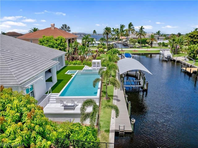 view of swimming pool with a water view, a boat dock, a lawn, and a patio