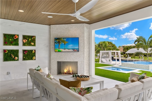 exterior space featuring ceiling fan, an outdoor fireplace, wood ceiling, and concrete flooring