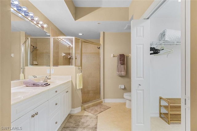 bathroom with vanity, tile patterned flooring, toilet, and walk in shower