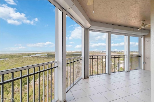 unfurnished sunroom featuring ceiling fan