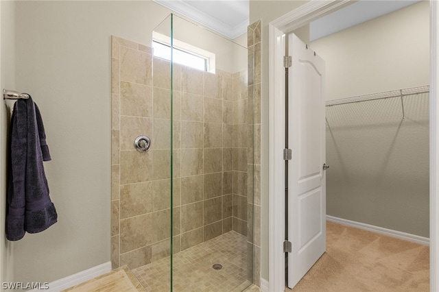 bathroom with ornamental molding and tiled shower