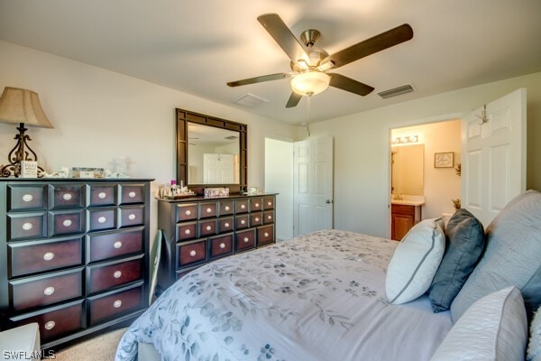 carpeted bedroom featuring ensuite bath and ceiling fan