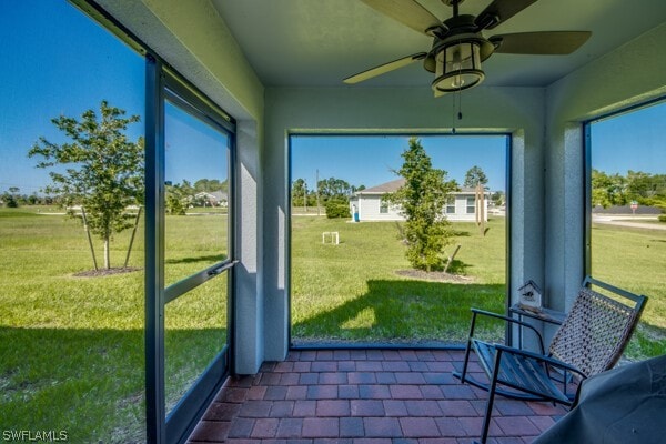 unfurnished sunroom with ceiling fan