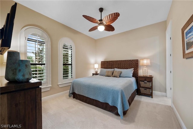 bedroom with ceiling fan and light carpet